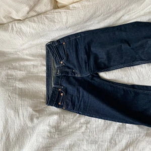 Mörkblå Weekday jeans - Säljer ett par mörkblå jeans från Weekday i modellen Arrow Low Straight. Klassisk femficksdesign med dragkedja och knapp, kontrastsömmar och rak passform. Använda en del men inga defekter, säljer på grund av att de har blivit för små!