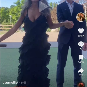 Svart balklänning eller långklänning med volanger från NA-KD - Supersnygg svart långklänning från NA-KD med tunna axelband och massor av volanger som ger en riktigt festlig känsla. Klänningen har en v-ringad urringning och är perfekt för bal eller festliga tillfällen. Endast använd 2 gånger