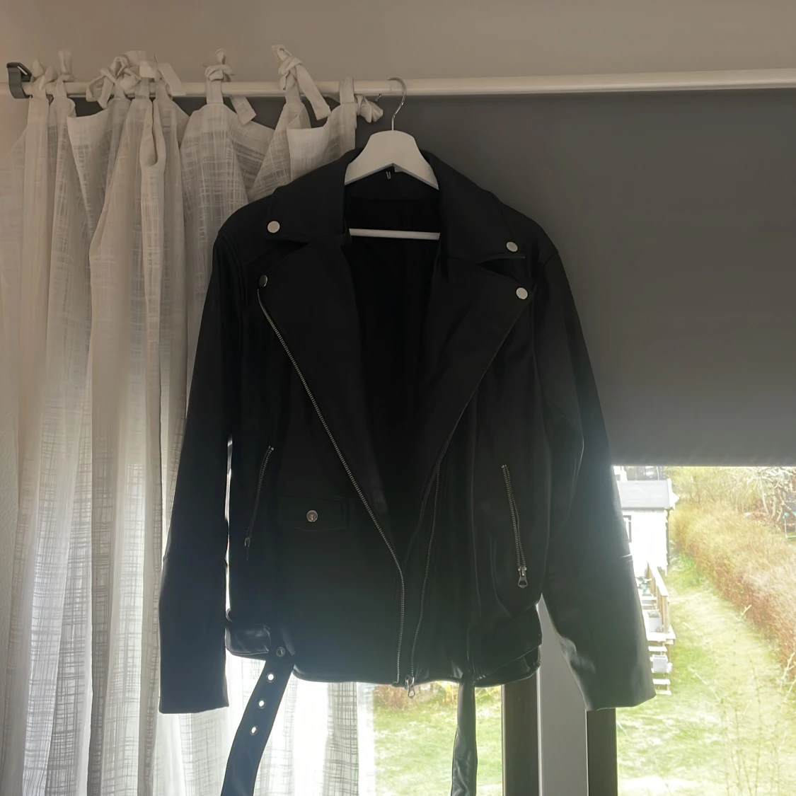 Svart skinnjacka med dragkedjor och bälte