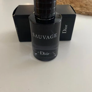 Sauvage herrparfym från Dior - Sauvage från Dior är en ikonisk herrparfym med fräsch och kryddig doft. Flaskan är elegant i mörkblått glas med svart kork och tydlig logga. Perfekt för dig som gillar exklusiva och moderna dofter.