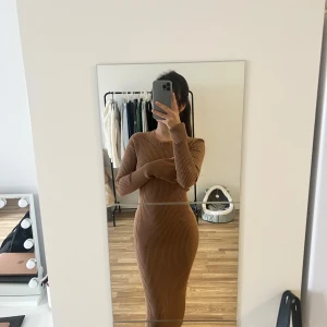 Ribbad klänning - Säljer en tight, ribbad långklänning i ljusbrun/mörkbeige färg. Klänningen har långa ärmar med slits och rund halsringning. Perfekt för dig som gillar en enkel men stilren look. Storlek S. Dock väldigt stretchig passar XS-M. 