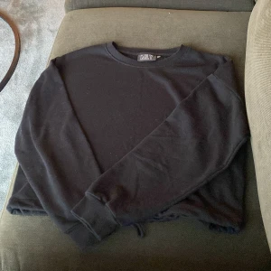 Svart sweatshirt från MLY - En enkel svart sweatshirt från MLY i storlek M. Tröjan har rund halsringning, långa ärmar och ribbade muddar vid ärmslut och nederkant. Perfekt för en avslappnad stil.