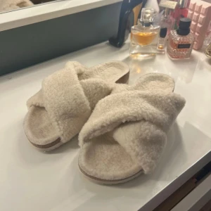 Beiga fluffiga sandaler med korsade band - Aldrig använda eftersom jag inte haft användning för dom. Super fina och mysiga tofflor i storlek 37/38. Super fina till sommaren. Pris kan diskuteras 