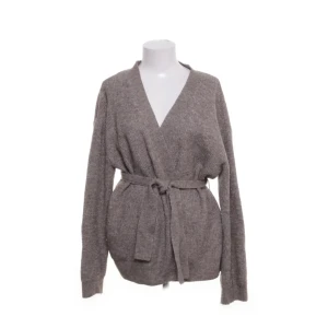 Beige kofta med bälte från H&M - Mysig beige/brun kofta från H&M med knytskärp i midjan och lång ärm. Tillverkad i en mjuk blandning av polyester, akryl, ull och elastan. Perfekt för lager-på-lager och enkel att styla till olika outfits. Helt ny men lappen är inte längre kvar💗