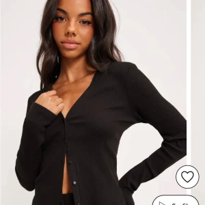 Janeva cardigan, Pices - Svart ribbad kofta från Pieces med v-ringning och knappar framtill. Långärmad och i mjukt, stretchigt material. Helt oanvänd.