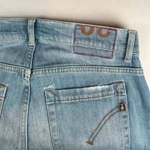Dondup jeans - Säljer ett par ljusblå dondup jeans med slitningar på både fram- och baksida. 