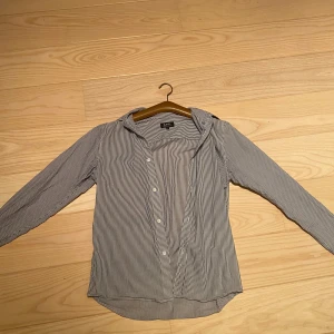 Randig skjorta från A.P.C. - Säljer en klassisk vit och blå randig skjorta från A.P.C. Skjortan har lång ärm, knappar framtill och en tidlös krage. Perfekt för dig som gillar stilrena plagg med fransk känsla. Skriv om ni har några funderingar! Priset går att diskutera.