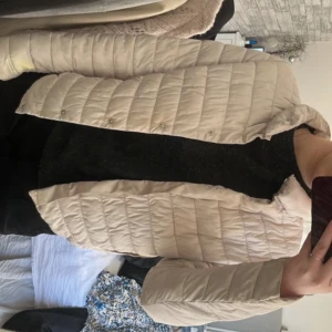 Vårjacka  - Säljer en beige quiltad pufferjacka med knappar framtill. Super snygg! Passar perfekt som vårjacka, i väldigt bra skick 