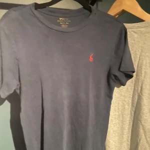 Mörkblå t-shirt från Ralph Lauren - Säljer en mörkblå t-shirt från Ralph Lauren med klassisk röd broderad logga på bröstet. 