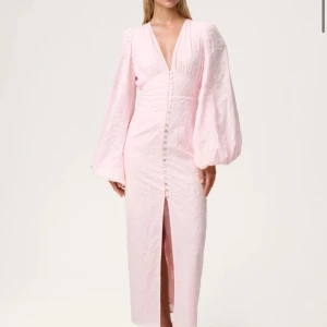 Ljusrosa adooreklänning - Superfin ljusrosa långklänning med djup v-ringning, markerad midja och långa puffärmar. Slutsåld på hemsidan