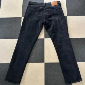 Svarta Levi's 511 jeans - Säljer ett par svarta Levi's 511 jeans med klassisk femficksdesign och raka ben. Jeansen har en snygg tvättad finish och är tillverkade i mjukt denimtyg.