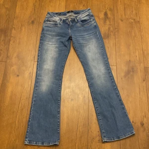 Blå bootcut jeans från LTB - Säljer ett par blåa low waist, bootcut jeans från LTB, modell Valerie. Jeansen har fem fickor (inklusive den lilla fickan i vänstra fickan) , ljusa slitningar framtill och bak. Strl 26x30… Nästan oanvända då dom blev för stora. Nypris: 799 kr Mitt pris: 650 kr. PRIS KAN DISKUTERAS 