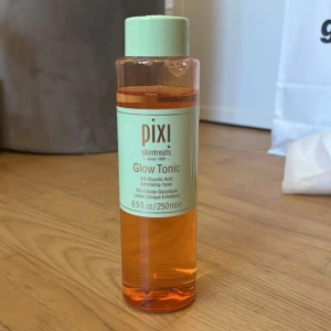 Pixi Glow Tonic 250 ml - Pixi Glow Tonic är en exfolierande toner med 5% glykolsyra som hjälper till att ge huden lyster och jämnare hudton. Kommer i en genomskinlig plastflaska med mintgrönt lock och etikett. Innehåller 250 ml. Knappt använd och flaskan är nästan full.