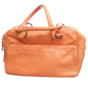 Handväska från Strauss - Säljer en orange handväska från Strauss med två handtag och dragkedja upptill. Köpt secondhand och knappt använd. Väskan har en stor ytterficka med dragkedja. Lite fläckig på insidan (se sista bilden) men toppskick på utsidan! 🔥