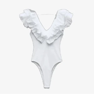 Vit popular volangbody från Zara - Supersnygg vit body från Zara med djup v-ringning och stora volanger längs axlar och halsringning. Kroppsnära passform och ärmlös design, perfekt att styla med jeans eller kjol för en trendig look. Storlek m men passa xs