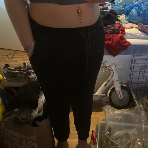 Svarta mjukisbyxor med resårmidja - Säljer ett par svarta mjukisbyxor i storlek M. Byxorna har resår i midjan och dragsko för justerbar passform samt fickor på sidorna. Perfekta för en avslappnad stil och riktigt sköna att ha på sig.