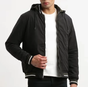 Svart quiltad bomberjacka med huva från Hollister - Säljer en svart quiltad bomberjacka från Hollister med huva och dragkedja. Jackan har vita och svarta ribbade muddar vid ärmslut och midja samt två fickor med dragkedja framtill. Perfekt för alla väder!