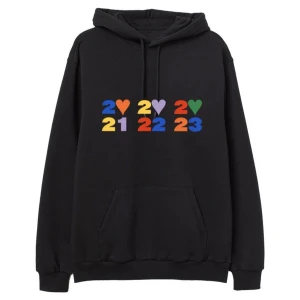 Harry Styles Love On Tour hoodie - Svart hoodie från Harry Styles Love On Tour med färgglada tryck fram och bak. Framsidan har årtalen 2021, 2022, 2023 i blått, gult, lila, rött, grönt och orange med hjärtan. Baksidan har turnéstäder och regnbågsfärgad text. Känguruficka och huva med snörning. Ny pris 750kr