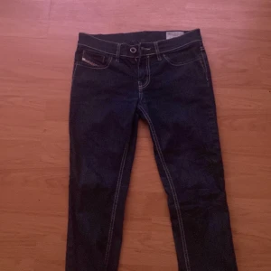 Mörkblå jeans med raka ben - Säljer ett par klassiska mörkblå jeans med kontrastsömmar och raka ben. Byxorna har normal passform och traditionell femficksdesign. Perfekta till vardags och lätta att matcha med olika stilar. W27 L32