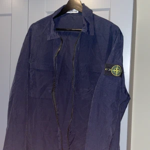 Mörkblå overshirt/windbreaker från Stone Island - Säljer denna marinblå overshirten/windbreakern från Stone Island. Jackan är endast påprovad och inte använd. 10/10 skick och den är självfallet äkta. Nypris ligger runt 4-5 tusen! Hör gärna av dig vid frågor 