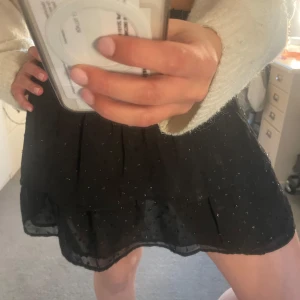 Svart volangkjol med små glittriga detaljer - Supersöt svart kortkjol med volanger och små glittriga prickar.Super fin att använda som volang topp också.Pris går att diskutera💕