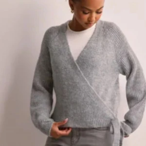 Grå omlott kofta i stickat material - Supermysig grå omlott kofta i stickat material med knyt i sidan. Använd 2 gånger💓
