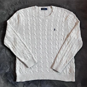 Ralph Lauren kabelstickad  - Säljer en helt ny kabelstickad tröja i ljusgrått från Polo Ralph Lauren. 