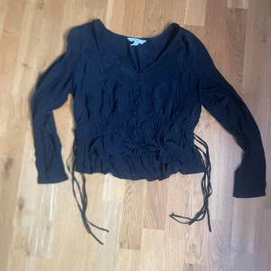 Svart blus - Säljer denna jätte fina blus från hm med rosetter i sidorna 🩷