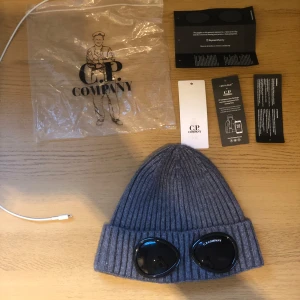 Grå CP.Company mössa - Grå CP.Company mössa. Org pris: 1300 från kidsbrandstore. Använt ca 10 gånger köpte för 1 månad sen. Har kvar påsen och lapparna som kom med det får ni även med om ni köper. Mössan skickas inom 2 dagar efter köp🚀. Riktigt fet mössa för ett bra pris säljer pga att jag ska byta stil😃 priset ej hugget i sten 🪨🪓 skriv till mig med minsta frågor. Mvh Linus 