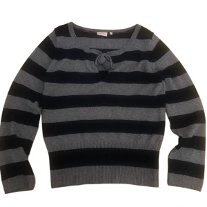 2000s vintage y2k Randig tröja från Jackpot - Säljer en snygg randig tröja från Jackpot i grått och svart. Tröjan har långa ärmar och en knytning framtill som en fin detalj. Super good condition no flaws! Tag doesnt have a size but id say like a S-M.💓