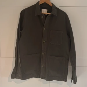 Grön overshirt  - Säljer en stilren grön overshirt från A day’s march.  Perfekt overshirt inför våren/sommaren. Storleken är M. Vid funderingar av frågor så är det bara höra av sig! 