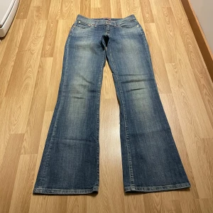 Lågmidjade bootcut jeans  - (27) Lågmidjade bootcut jeans med snygg unik tvätt och i stretchiga material. Midjemått rakt över: 35cm, innerbenslängd: 81 cm💕
