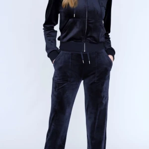 Marinblått juicy mjukissett - Snygga marinblåa mjukisbyxor. Byxorna har en bekväm passform med elastisk midja och snörning. Perfekta för en avslappnad stil med fickor både fram och bak.