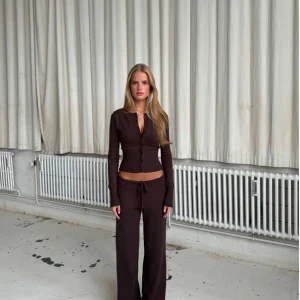 Bruna mjukisbyxor med knytning - Snygga bruna mjukisbyxor från Venderby's med knytning i midjan. Helt oanvända kommer i förpackning och med lapp. Matchande kofta finns även vid intresse! Storlek s/m