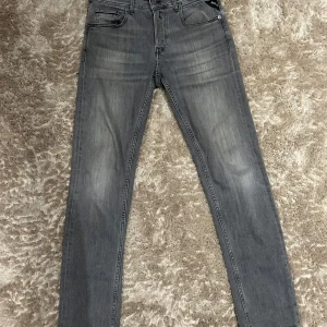 Replay Grover Hyperflex - Snygga grå jeansbyxor med en klassisk femficksdesign. De har en rak passform och är perfekta för en stilren look. Byxorna har en diskret tvättad effekt och en knappgylf.