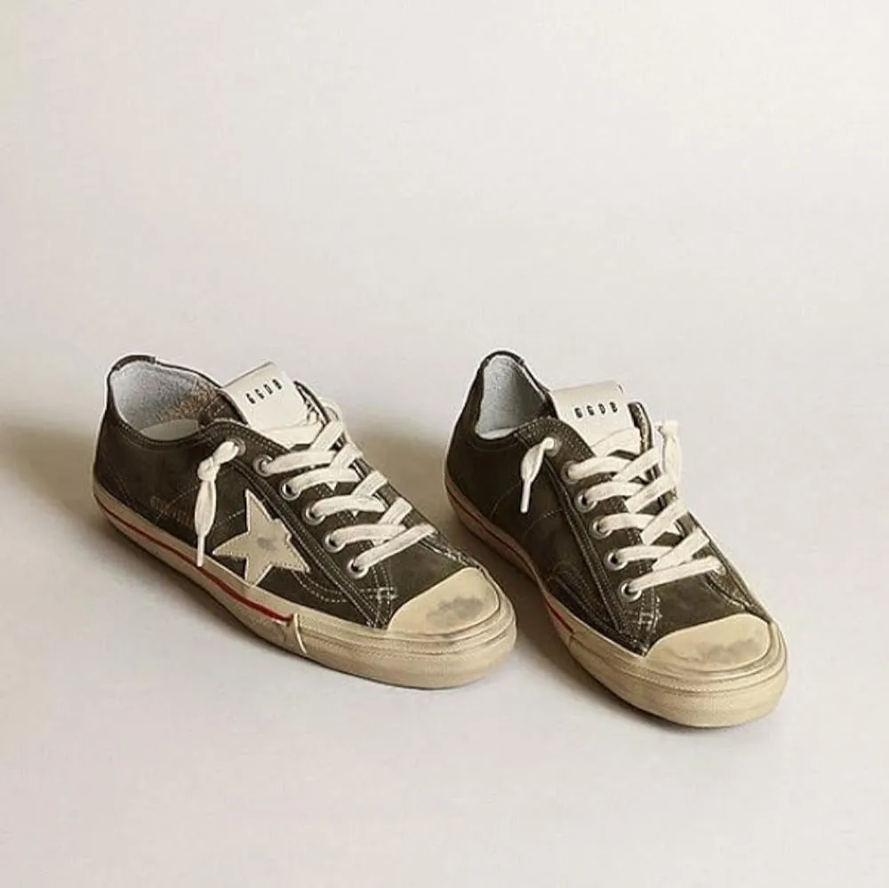 Snygga olivgröna sneakers från Golden Goose med en vit stjärna på sidan. Skorna har en klassisk snörning och en vit sula med en lätt sliten look för en vintagekänsla. Perfekta för en avslappnad stil.. Kengät.