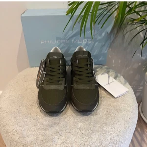 Gröna sneakers från Philippe Model - Snygga gröna sneakers från Philippe Model med vita detaljer och snörning. Skorna har en modern design med en robust sula och är tillverkade i slitstarkt. Dom är i 9/10 skick pris är diskuterbart