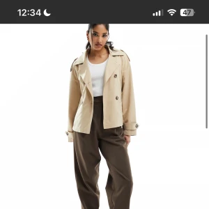 Beige trenchcoat - Snygg beige trenchcoat med klassisk design och knappar framtill. Slutsåld från Stradivarius, inprincip oanvänd