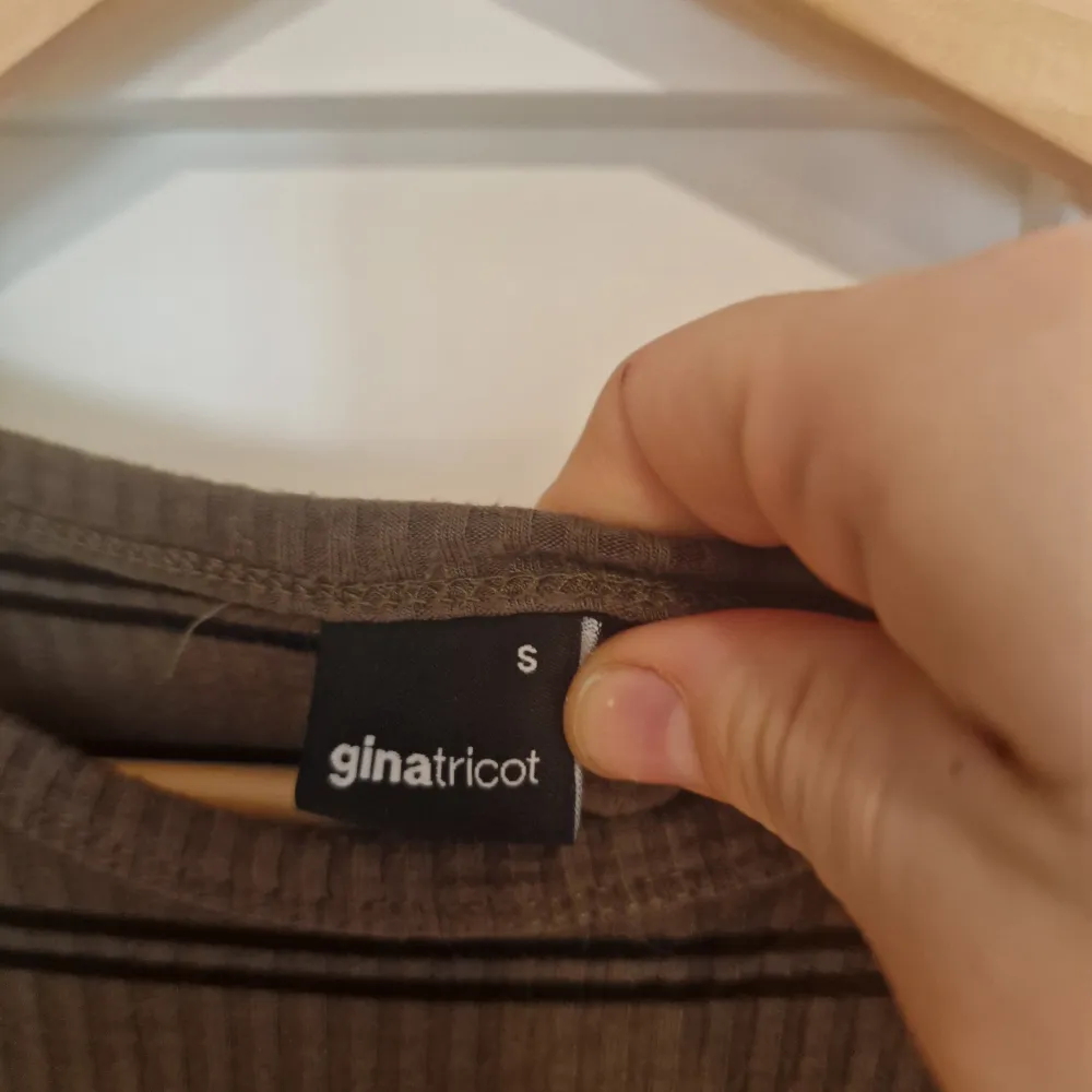 Snygg randig klänning från Gina Tricot i bruna och svarta toner. Klänningen har en tight passform och är långärmad, perfekt för höst och vinter. Den är gjord i ett ribbat material som är otroligt bekvämt. Perfekt för att hålla stilen även om det känns som att du går runt i pyamas. . Mekot.