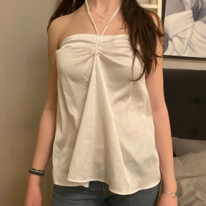 Vit satintopp  - Såå fin halterneck topp i silkesmaterial💓 Sista bilderna visar att det är ihopsytt under armhålorna, men det syns inte när man har på sig den! Pris går att diskutera vid snabb affär och det är bara att höra av sig vid frågor eller för fler bilder!💓 står ingen storlek men skulle säga xs/s