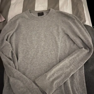Grå tröja från hm - Säljer en stilren grå tröja från hm. Tröjan har en klassisk rund hals och långa ärmar, perfekt för en avslappnad look. Den är tillverkad i ett mjukt material som känns skönt mot huden. Storlek S/M