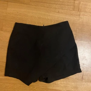 Svart kort shortskirt  - Sälje r denna superfina shortsen som är som en kjol, perfekt inför sommaren😍 Köpt den utomlands och är i mycket bra skick. Varit en av mina favoriter men håller på att rensa mitt garderob därför säljer jag!! Passar perfekt ifall du ska på middag med ett par långa boots med svarta genomskinliga strumpbyxor+  en stickad tröja 😍😍