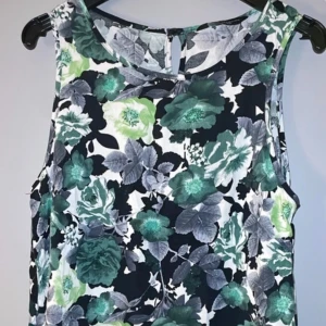 Blommig ärmlös klänning från Dorothy Perkins - Säljer en snygg blommig klänning från Dorothy Perkins. Den är ärmlös med ett vackert mönster i gröna och svarta nyanser. Perfekt för en somrig look! 🌸