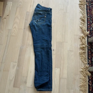 Dondup george  - Snygga blå jeans från dondup med coola slitningar på fram- och baksida. De har en klassisk femficksdesign och en knappgylf. Perfekta för en avslappnad stil. Just Denna byxa har varit mycket eftertraktad och säljer den för den är tyvärr för små för mig! STEAL!!!