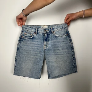 Blå jeansshorts - Snygga blå jeansshorts från Levi's med klassisk femficksdesign och råa kanter. Perfekta för en avslappnad stil. De har en knappgylf och är tillverkade i slitstarkt denim.