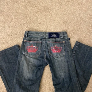 Victoria Beckham jeans - Skit snygga bootcut Victoria Beckham jeans med broderade rosa kronor på bakfickorna. Vet tyvärr inte storleken då lappen har rivits bort. Innerbenslängden: 72 cm / Midjemåttet rakt över: 37 cm / Grenhöjd: 19 cm 