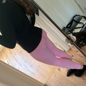 Rosa träningstights - Snygga rosa leggings i ett stretchigt syntetmaterial med hög midja. Perfekta för träning eller en avslappnad dag. Tillverkade av 90% polyamid och 10% spandex för en bekväm passform.