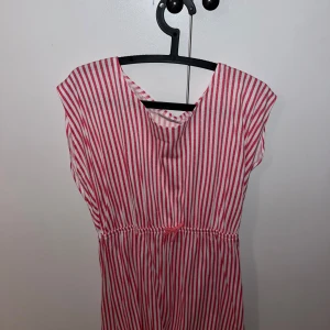 Sommarklänning - Säljer en söt rosa- och vitrandig klänning från Skill. Klänningen har en bekväm passform med korta ärmar. Perfekt för en avslappnad dag ute. 🌸skriv för fler bilder 