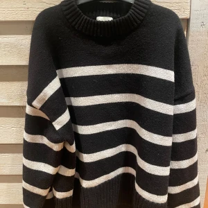 Svart och vit randig tröja - Säljer en svart och vit randig tröja med ribbad krage och muddar. Tröjan har en avslappnad passform och är perfekt för kyligare dagar. Den är långärmad och gjord i ett mjukt material som känns skönt mot huden, välvårdad och knappt använd☺️