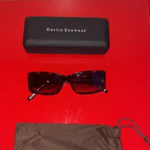 Snygga rektangulära solglasögon från Corlin Eyewear i en stilren brun färg. Perfekta för att ge en cool touch till din outfit. Kommer med ett praktiskt fodral för säker förvaring. Ordinarie pris - 1 400 SEK
